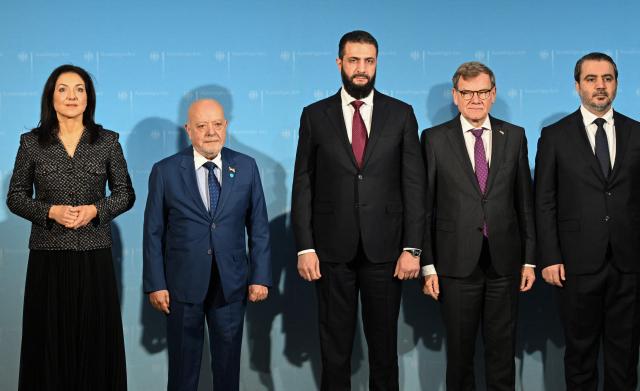 (L-R) German Economy and Energy Minister Katherina Reiche, Syrian Economy and Industry  Minister Mohammad Nidal Alshaar, Syrian President Ahmed al-Sharaa, German Foreign Minister Johann Wadephul and Syrian Foreign Minister Asaad al-Shibani pose ahead a German-Syrian roundtable meeting on economy at the Foreign Ministry in Berlin on March 30, 2026. Syria's President Ahmed al-Sharaa visits Germany on Monday for talks on the Middle East war, rebuilding his country and Berlin's efforts to send back Syrian refugees. (Photo by RALF HIRSCHBERGER / AFP)