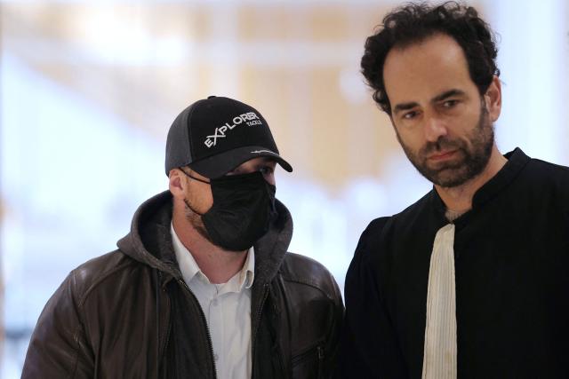 Defendant Dylan Bilheude (L) arrives for the opening of the so-called Athanor trial, in which 22 people are facing a wide range of charges, including murder, centred on the Athanor Masonic lodge accused of running hit squads, at the Assize Court in the Tribunal Judiciaire courthouse in Paris, on March 30, 2026. The 22 defendants are accused of murder, attempted murder, aggravated assault and criminal conspiracy on behalf of a mafia network inside the Athanor Masonic Lodge in the Paris suburb of Puteaux. At least four freemasons from the 20 or so members of the lodge are in the dock. Other defendants include four officers from France's DGSE foreign intelligence service, three police officers, six business executives, a security guard, a doctor and an engineer. (Photo by Thomas SAMSON / AFP)