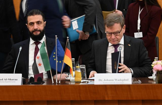 Syrian President Ahmed al-Sharaa (L) and German Foreign Minister Johann Wadephul attend a German-Syrian roundtable meeting on economy at the Foreign Ministry in Berlin on March 30, 2026. Syria's President Ahmed al-Sharaa visits Germany on Monday for talks on the Middle East war, rebuilding his country and Berlin's efforts to send back Syrian refugees. (Photo by RALF HIRSCHBERGER / AFP)