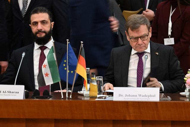 Syrian President Ahmed al-Sharaa (L) and German Foreign Minister Johann Wadephul attend a German-Syrian roundtable meeting on economy at the Foreign Ministry in Berlin on March 30, 2026. Syria's President Ahmed al-Sharaa visits Germany on Monday for talks on the Middle East war, rebuilding his country and Berlin's efforts to send back Syrian refugees. (Photo by RALF HIRSCHBERGER / AFP)