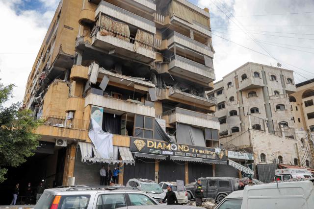 People and first-responders gather before a building that was hit by an Israeli airstrike in Beirut’s southern suburbs on March 30, 2026. A strike hit Beirut's southern suburbs on March 30 after Israel issued a warning for people in the Hezbollah stronghold to leave. The strike is the first since March 27 in the area, which is now largely deserted since Israel began frequent attacks against Hezbollah earlier in the month. (Photo by Anwar AMRO / AFP) / 