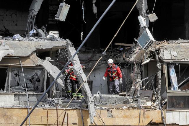 First-responders search a heavily-damaged building that was hit by an Israeli airstrike in Beirut’s southern suburbs on March 30, 2026. A strike hit Beirut's southern suburbs on March 30 after Israel issued a warning for people in the Hezbollah stronghold to leave. The strike is the first since March 27 in the area, which is now largely deserted since Israel began frequent attacks against Hezbollah earlier in the month. (Photo by Anwar AMRO / AFP) / 