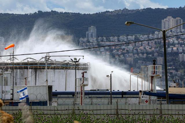 Firefighters attempt to extinguish a fire following a projectile impact on a refinery in Israel's northern city of Haifa on March 30, 2026. Israel and Iran exchanged more missile fire on March 30 as concerns that the US might escalate the Middle East conflict by launching ground raids against the Islamic republic's Gulf islands sent oil prices soaring. (Photo by Jack GUEZ / AFP)