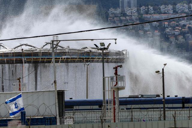 Firefighters attempt to extinguish a fire following a projectile impact on a refinery in Israel's northern city of Haifa on March 30, 2026. Israel and Iran exchanged more missile fire on March 30 as concerns that the US might escalate the Middle East conflict by launching ground raids against the Islamic republic's Gulf islands sent oil prices soaring. (Photo by Jack GUEZ / AFP)