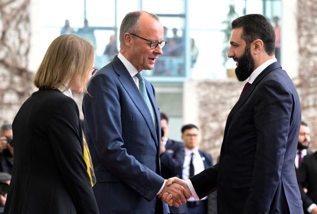 German Chancellor Friedrich Merz (2L) welcomes Syrian President Ahmed al-Sharaa at the Chancellery in Berlin on March 30, 2026. Syria's President Ahmed al-Sharaa visits Germany on Monday for talks on the Middle East war, rebuilding his country and Berlin's efforts to send back Syrian refugees. (Photo by John MACDOUGALL / AFP)