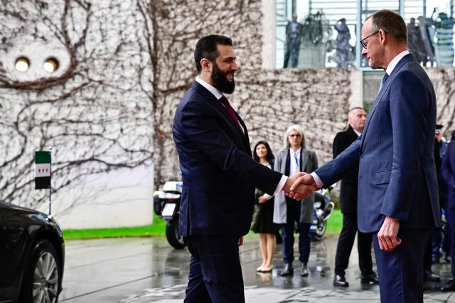 German Chancellor Friedrich Merz (R) welcomes Syrian President Ahmed al-Sharaa at the Chancellery in Berlin on March 30, 2026. Syria's President Ahmed al-Sharaa visits Germany on Monday for talks on the Middle East war, rebuilding his country and Berlin's efforts to send back Syrian refugees. (Photo by Tobias SCHWARZ / AFP)