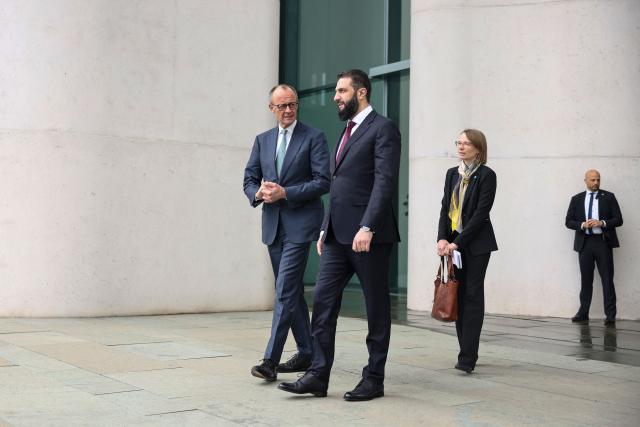 German Chancellor Friedrich Merz walks with Syrian President Ahmed al-Sharaa at the terrace of the Chancellery ahead of their bilateral talks on March 30, 2026 in Berlin. Syria's President Ahmed al-Sharaa visits Germany on Monday for talks on the Middle East war, rebuilding his country and Berlin's efforts to send back Syrian refugees. (Photo by Nadja Wohlleben / POOL / AFP)