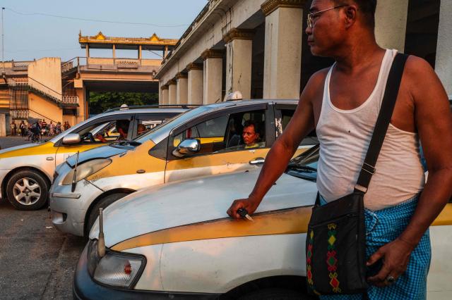 Taxi drivers wait for customers outside the Central Railway Station in Yangon on March 29, 2026. (Photo by ANTHONY WALLACE / AFP)