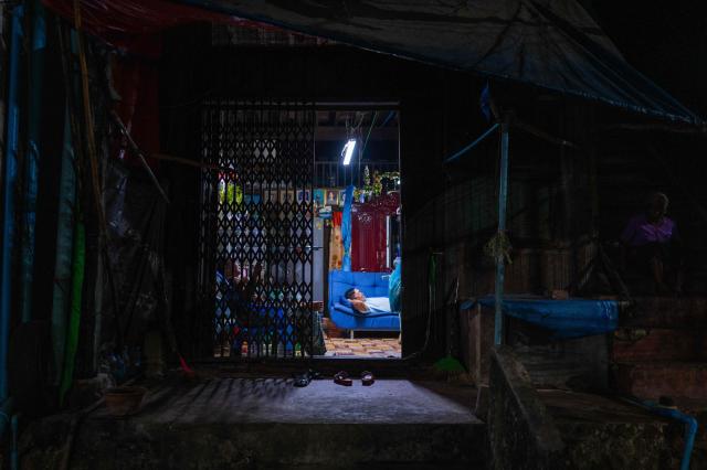 A man and a woman watch television in their home in Yangon on March 29, 2026. (Photo by ANTHONY WALLACE / AFP)