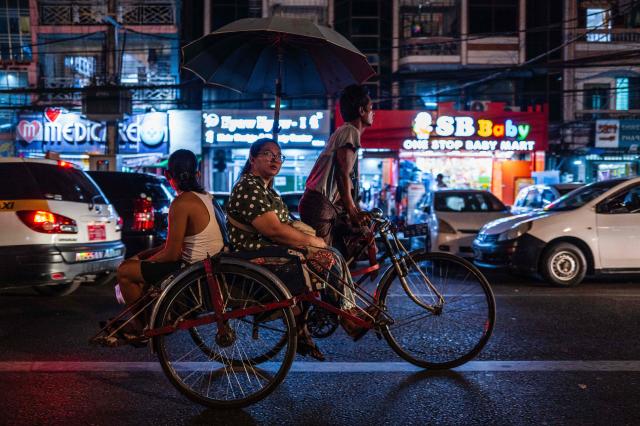 Passengers take a trishaw taxi along a road in Yangon on March 29, 2026. (Photo by ANTHONY WALLACE / AFP)