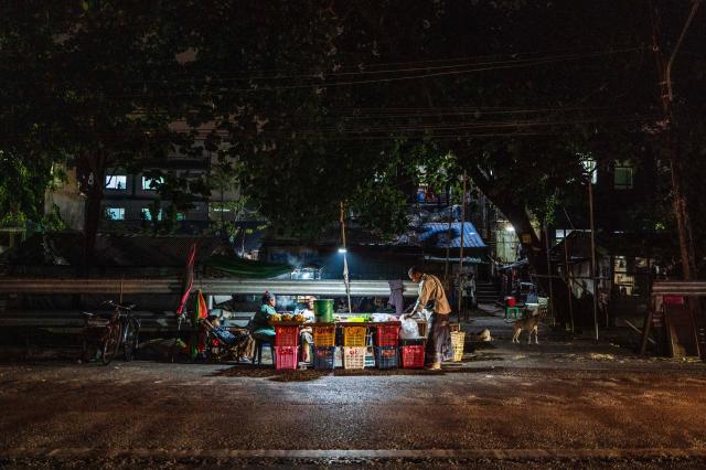 Vendors wait for customers at their roadside stall in Yangon on March 29, 2026. (Photo by ANTHONY WALLACE / AFP)