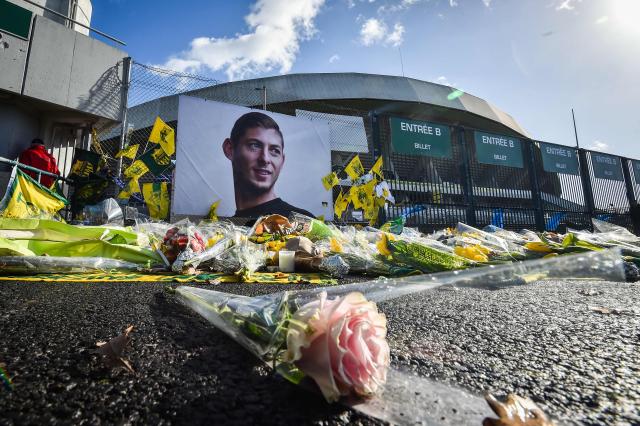 (FILES) Flowers are displayed in front of the portrait of Argentinian forward Emiliano Sala at the Beaujoire stadium in Nantes, on February 10, 2019. The commercial court of Nantes is due to deliver its decision on March 30, 2026 regarding the financial dispute between the two clubs, seven years after the death of Emiliano Sala in a plane crash. Sala, 28, died in a plane crash having inhaled toxic levels of carbon monoxide from the aircraft's faulty exhaust system during an unlicensed 2019 flight en route from Nantes to Cardiff. (Photo by LOIC VENANCE / AFP)