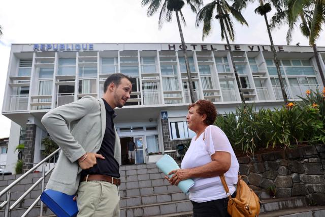 Left-wing La France Insoumise (LFI) mayor of Le Tampon Alexis Chaussalet (L) speaks with an inhabitant in front of the town hall in Le Tampon, on the French Indian ocean island of La Réunion, on March 30, 2026. (Photo by Richard BOUHET / AFP)