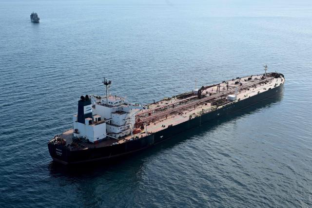 (FILES) This aerial picture taken on October 1, 2025 off the coast of the western France port of Saint-Nazaire shows the tanker Boracay from Russia's so-called "shadow fleet" suspected of being involved in drone flights over Denmark which sailed off the Danish coast between September 22 and 25, with a boat of the French Navy in the background. The Chinese captain of the Boracay, a tanker from the Russian shadow fleet that was seized in September by the French navy off the coast of Brittany, was sentenced on March 30, 2026 to one year in prison by the Brest criminal court for "failing to comply with orders."
Chen Zhangjie, 39, who was not present when the judgment was delivered, was also fined 150,000 euros. The court issued an arrest warrant against him.
Named the Pushpa or Boracay, the Benin-flagged vessel, which is blacklisted by the European Union for being part of Russia's sanction-busting "shadow fleet", has been immobilised for several days off the French coast. (Photo by Damien MEYER / AFP)
