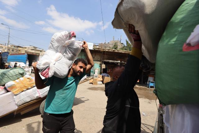 Workers load goods onto trucks at a transport garage in the Maidan area of central Baghdad on March 30, 2026. As cargo ships remain unable to enter Iraq's port of Umm Qasr along the Gulf due to the closure of the Hormuz Strait due to the war between Iran and the US and Israel, Iraq's trade has been severely impacted negatively, depending mainly now on overland transport. (Photo by AHMAD AL-RUBAYE / AFP)