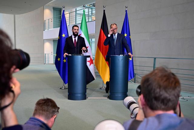 German Chancellor Friedrich Merz (R) and Syrian President Ahmed al-Sharaa address a joint press conference after talks at the Chancellery in Berlin on March 30, 2026. Syria's President Ahmed al-Sharaa visits Germany on Monday for talks on the Middle East war, rebuilding his country and Berlin's efforts to send back Syrian refugees. (Photo by John MACDOUGALL / AFP)