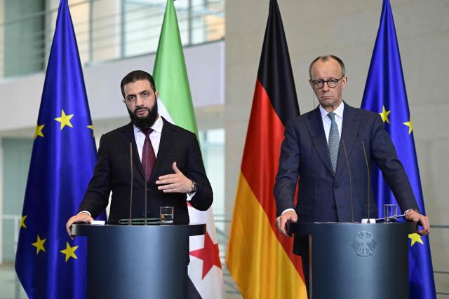 German Chancellor Friedrich Merz (R) and Syrian President Ahmed al-Sharaa address a joint press conference after talks at the Chancellery in Berlin on March 30, 2026. Syria's President Ahmed al-Sharaa visits Germany on Monday for talks on the Middle East war, rebuilding his country and Berlin's efforts to send back Syrian refugees. (Photo by John MACDOUGALL / AFP)