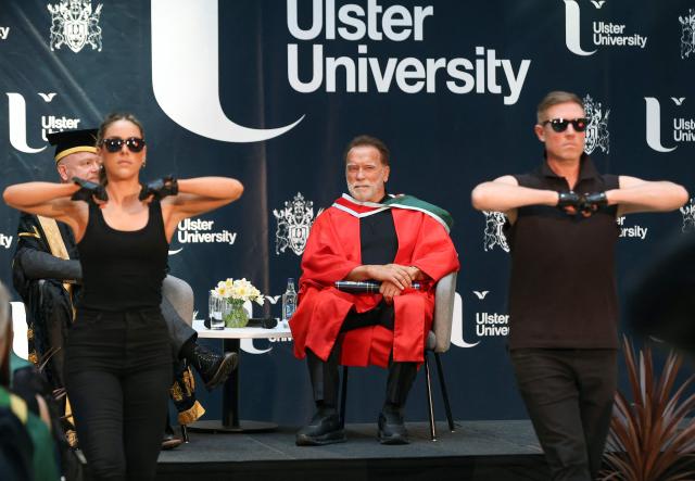 Hollywood actor and former California state governor, Arnold Schwarzenegger, watches a musical performance at a ceremony to receive an honorary doctorate from Ulster University in Belfast, Northern Ireland, on March 30, 2026. (Photo by Paul Faith / AFP)