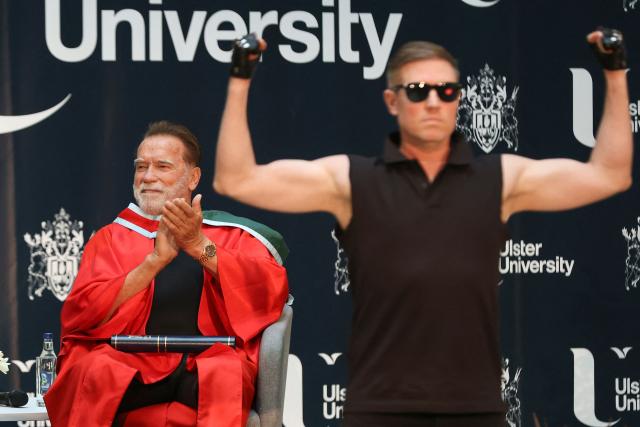 Hollywood actor and former California state governor, Arnold Schwarzenegger, watches a musical performance at a ceremony to receive an honorary doctorate from Ulster University in Belfast, Northern Ireland, on March 30, 2026. (Photo by Paul Faith / AFP)