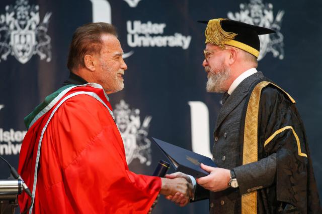 Hollywood actor and former California state governor, Arnold Schwarzenegger (L) recieves an honorary doctorate from Ulster University Chancellor Dr. Colin Davidson at Ulster University in Belfast, Northern Ireland, on March 30, 2026. (Photo by Paul Faith / AFP)