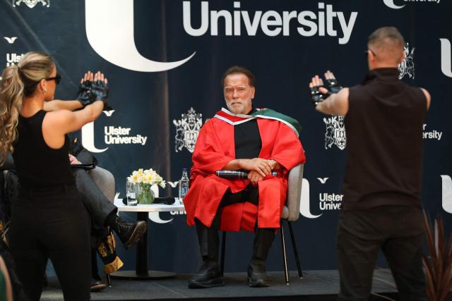 Hollywood actor and former California state governor, Arnold Schwarzenegger, watches a musical performance at a ceremony to receive an honorary doctorate from Ulster University in Belfast, Northern Ireland, on March 30, 2026. (Photo by Paul Faith / AFP)