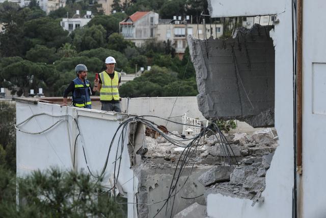 Workers assess the damage to an apartment after an Iranian strike hit a residential neighbourhood in Haifa, on March 30, 2026. The Middle East was sparked by joint US-Israeli strikes on Iran that triggered a wave of retaliatory missile and drone attacks against Israel and several other countries in the region. (Photo by Jack GUEZ / AFP) / 