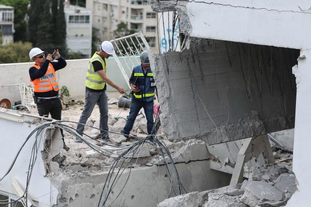 Workers assess the damage to an apartment after an Iranian strike hit a residential neighbourhood in Haifa, on March 30, 2026. The Middle East was sparked by joint US-Israeli strikes on Iran that triggered a wave of retaliatory missile and drone attacks against Israel and several other countries in the region. (Photo by Jack GUEZ / AFP) / 