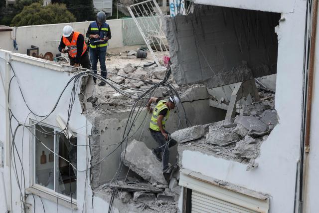 Workers assess the damage to an apartment after an Iranian strike hit a residential neighbourhood in Haifa, on March 30, 2026. The Middle East was sparked by joint US-Israeli strikes on Iran that triggered a wave of retaliatory missile and drone attacks against Israel and several other countries in the region. (Photo by Jack GUEZ / AFP) / 
