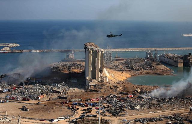 (FILES) A general view shows the damaged grain silos of Beirut's harbour and its surroundings on August 5, 2020, one day after a powerful twin explosion tore through Lebanon's capital, resulting from the ignition of a huge depot of ammonium nitrate at the city's main port. Lebanese judge Tarek Bitar has completed his investigation into the 2020 Beirut port blast, a years-long case that involves possible charges against dozens of people, a judicial official told AFP on March 30, 2026. Since 2023, the investigation into the massive Beirut port explosion, which killed more than 220 people on August 4, 2020, has been in jeopardy after Hezbollah led a campaign demanding the removal of Bitar, who was later hit with dozens of lawsuits to remove him from the case. (Photo by AFP)
