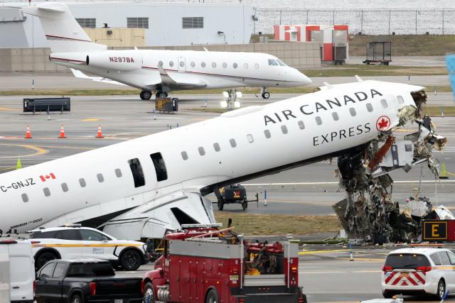 (FILES) An executive jet taxis behind the Air Canada Express CRJ-900 that collided with a Port Authority fire truck at LaGuardia Airport in New York, after the airport resumed operations on March 23, 2026. Air Canada said on March 30, 2026, that its CEO Michael Rousseau will retire later this year, in an announcement following controversy over his failure to issue condolences for a fatal airport disaster both in English and French. Rousseau has informed the company's board that he "will retire by the end of the third quarter" this year after nearly two decades of leadership, the firm said. (Photo by TIMOTHY A. CLARY / AFP)