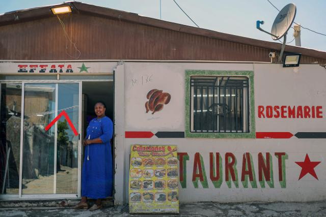 (FILES) Yvrose Jiam poses for a picture at the door of her shop and restaurant in the "Un Nuevo Amanecer” (A New Dawn) neighbourhood, Cerrillos commune, Metropolitan Region in Santiago, on November 11, 2025. Chile's new government led by far-right politician Josй Antonio Kast has halted the regularisation of 182,000 migrants in Chile, a process initiated by the previous administration of left-wing President Gabriel Boric, the Immigration Service told AFP on March 30, 2026. (Photo by Javier TORRES / AFP)