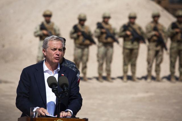 (FILES) Chile’s President Jose Antonio Kast speaks next to a group of soldiers near the Chacalluta border post along the Chile–Peru border on March 16, 2026. Chile's new government led by far-right politician Jose Antonio Kast has halted the regularisation of 182,000 migrants in Chile, a process initiated by the previous administration of left-wing President Gabriel Boric, the Immigration Service told AFP on March 30, 2026. (Photo by Patricio BANDA / AFP)