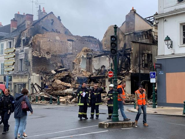 (FILES) Emergency personnel survey the scene of a burnt out building - which housed a pharmacy - in Montargis, some 100kms south of Paris on July 1, 2023, which was set alight overnight during continuing protests following the shooting of a teenage driver in the suburb of Nanterre on June 27. The hearing of a man on charges of deliberate destruction of property by arson during the June 2023 urban riots opens at Montargis's juvenile court on March 31, 2026. The defendant, who was 17 at the time, is accused of setting fire to the Mirabeau pharmacy, which collapsed in the aftermath of the blaze. (Photo by Mathieu RABECHAULT / AFP)