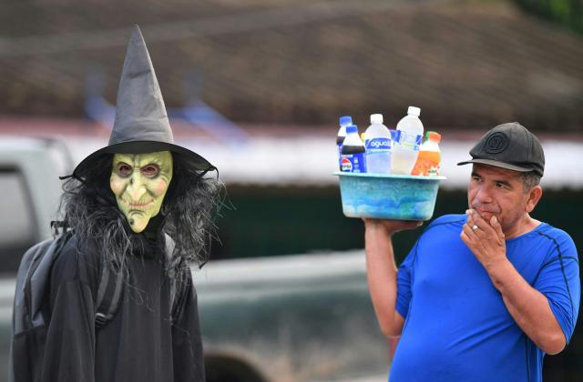 A fancy-dressed parishioner walks through the streets asking for money as part of the Holy Week folk tradition, in Santa Barbara, about 200 kilometers northwest of Tegucigalpa, on March 30, 2026. (Photo by Orlando SIERRA / AFP)