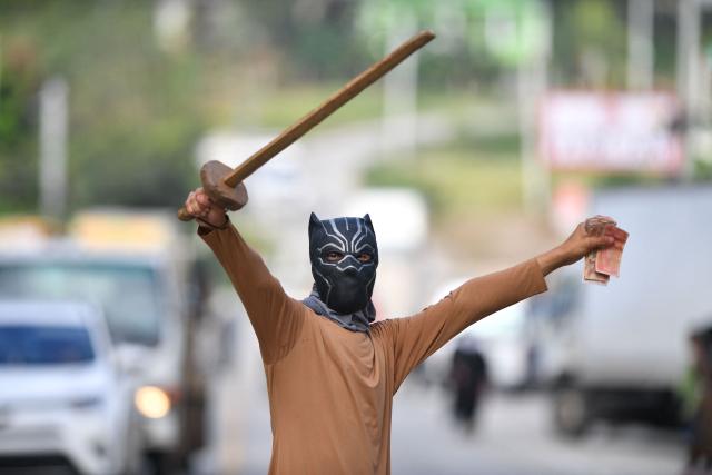 A fancy-dressed parishioner walks through the streets asking for money as part of the Holy Week folk tradition, in Santa Barbara, about 200 kilometers northwest of Tegucigalpa, on March 30, 2026. (Photo by Orlando SIERRA / AFP)
