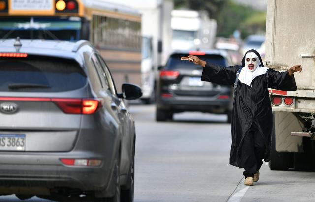 A fancy-dressed parishioner walks through the streets asking for money as part of the Holy Week folk tradition, in Santa Barbara, about 200 kilometers northwest of Tegucigalpa, on March 30, 2026. (Photo by Orlando SIERRA / AFP)