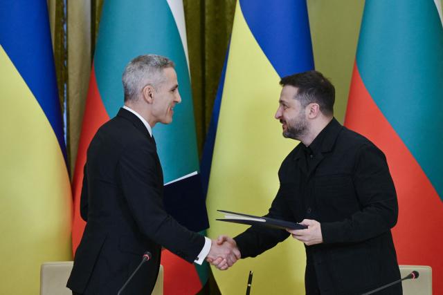 Ukraine's President Volodymyr Zelensky (R) and Bulgarian Prime Minister Andrey Gyurov shake hands as they exchange signed bilateral documents after a meeting in Kyiv on March 30, 2026, amid the Russian Invasion of Ukraine. (Photo by Genya SAVILOV / AFP)