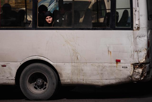 TOPSHOT - A woman looks out of a bus window in Beirut on March 30, 2026. Israel renewed its bombardment of Beirut's southern suburbs on March 30 while continuing air strikes on Lebanon's south, one of which targeted an army checkpoint and killed a soldier. Lebanon was pulled into the Middle East conflict when Tehran-backed armed group Hezbollah fired rockets at Israel on March 2 in revenge for the killing of Iran's supreme leader, the opening salvo in the US-Israeli war against the Islamic republic. (Photo by Dimitar DILKOFF / AFP)