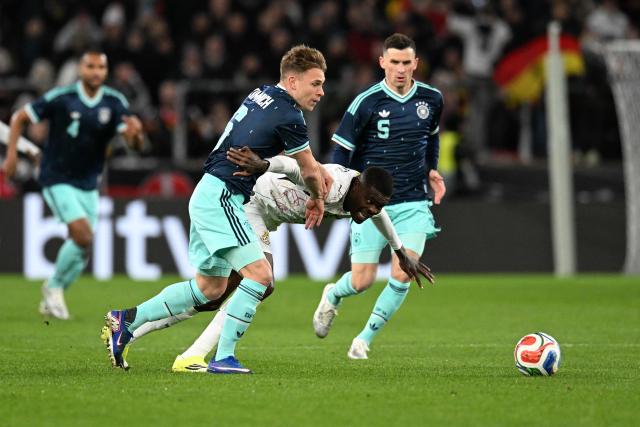 Germany's midfielder #05 Pascal Gross (R), Germany's defender #06 Joshua Kimmich (L) and Ghana's midfielder #05 Thomas Partey vie for the ball during the international friendly football match between Germany and Ghana in Stuttgart, southwestern Germany on March 30, 2026. (Photo by THOMAS KIENZLE / AFP)