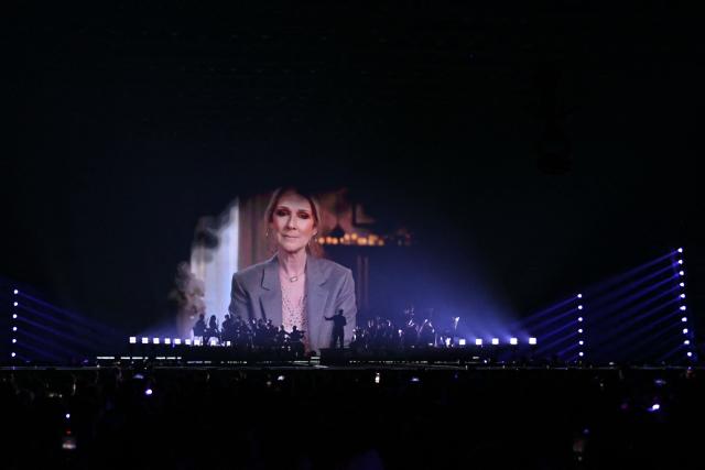 (FILES) A screen shows Canadian singer Celine Dion giving a recorded message to the contest during the first semi-final of the Eurovision Song Contest 2025, at the St. Jakobshalle arena in Basel on May 13, 2025. Quebec star Celine Dion officially announced on March 30, 2026, a series of ten concerts in Paris in September and October in Europe's largest indoor venue, near Paris, to mark her 58th birthday, confirming her return to the stage after six years away from the public. (Photo by SEBASTIEN BOZON / AFP)