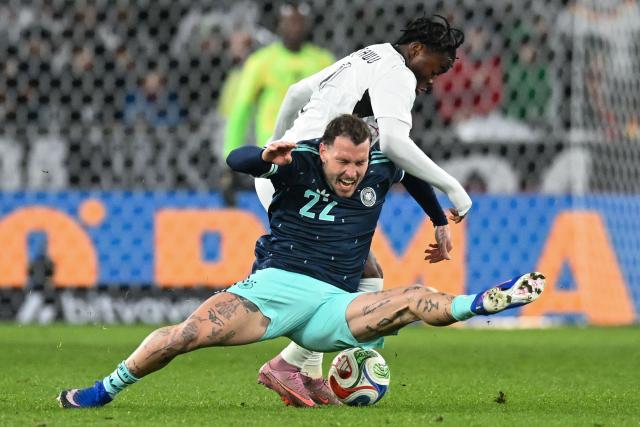 Ghana's forward #07 Fatawu Issahaku (back) and Germany's defender #22 David Raum vie for the ball during the international friendly football match between Germany and Ghana in Stuttgart, southwestern Germany on March 30, 2026. (Photo by THOMAS KIENZLE / AFP)
