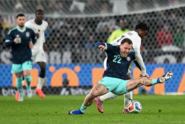 Ghana's forward #07 Fatawu Issahaku (back R) and Germany's defender #22 David Raum vie for the ball during the international friendly football match between Germany and Ghana in Stuttgart, southwestern Germany on March 30, 2026. (Photo by THOMAS KIENZLE / AFP)