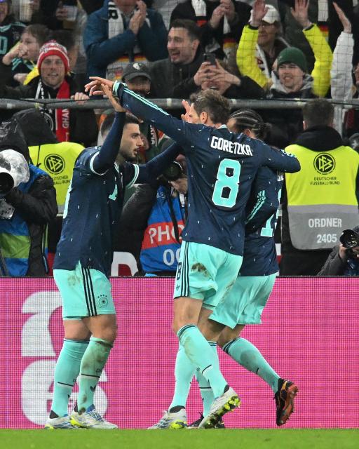 Germany's forward #13 Deniz Undav (L) celebrates scoring his team's second goal with teammates during the international friendly football match between Germany and Ghana in Stuttgart, southwestern Germany on March 30, 2026. Germany won the match 2-1. (Photo by THOMAS KIENZLE / AFP)