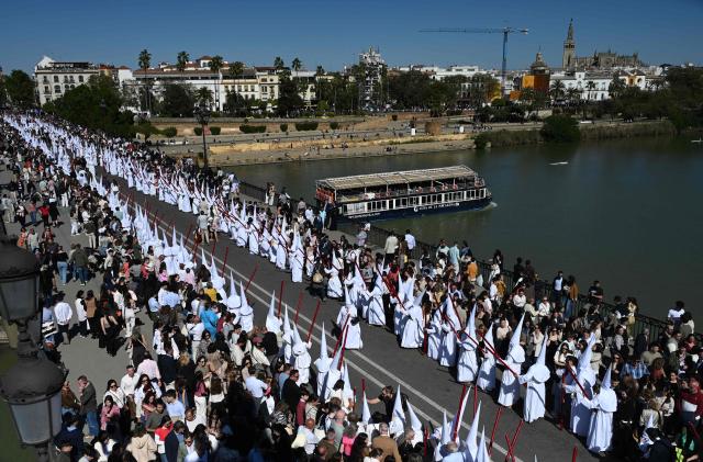 TOPSHOT - Penitents of the San Gonzalo brotherhood take part in the Holy Monday procession in Seville, Spain, on March 30, 2026. Christian believers around the world mark Holy Week in celebration of the crucifixion and resurrection of Jesus Christ. (Photo by CRISTINA QUICLER / AFP)