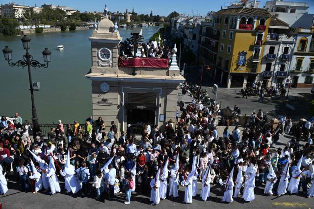 Penitents of the San Gonzalo brotherhood take part in the Holy Monday procession in Seville, Spain, on March 30, 2026. Christian believers around the world mark Holy Week in celebration of the crucifixion and resurrection of Jesus Christ. (Photo by CRISTINA QUICLER / AFP)
