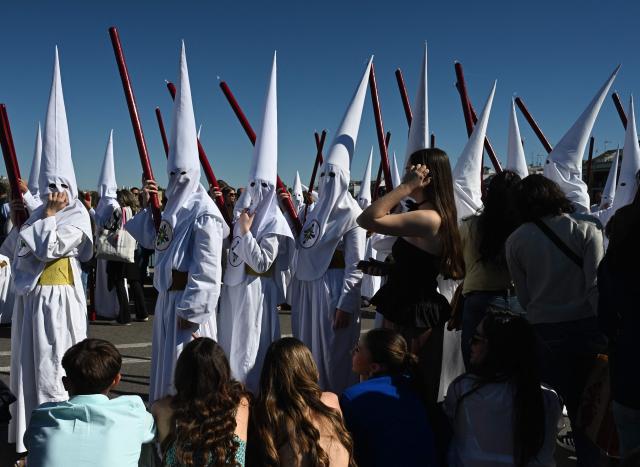 Penitents of the San Gonzalo brotherhood take part in the Holy Monday procession in Seville, Spain, on March 30, 2026. Christian believers around the world mark Holy Week in celebration of the crucifixion and resurrection of Jesus Christ. (Photo by CRISTINA QUICLER / AFP)
