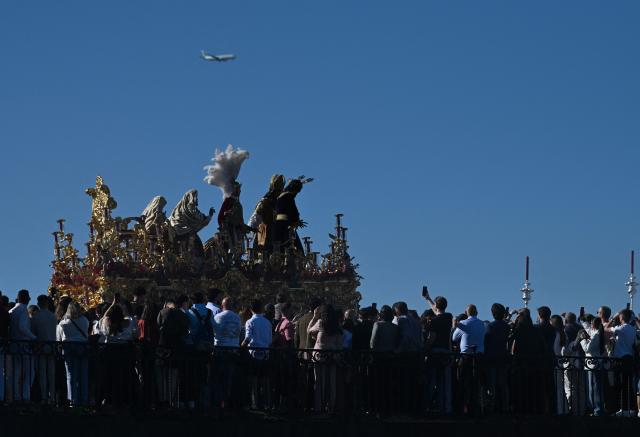 The image of Christ of the San Gonzalo brotherhood crosses a bridge during the Holy Monday procession in Seville, Spain, on March 30, 2026. Christian believers around the world mark Holy Week in celebration of the crucifixion and resurrection of Jesus Christ. (Photo by CRISTINA QUICLER / AFP)