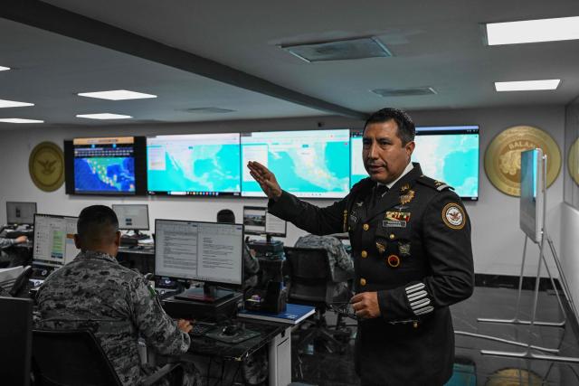 Colonel Rodolfo Blancas, Director of Planning and Supervision for Highways, Airports, Ports, and Borders of Mexico's National Guard, explains the operation of a road monitoring center during an interview with AFP at the National Guard headquarters in the Iztapalapa district of Mexico City on March 30, 2022. Cargo transport robbery in Mexico has decreased in recent months, which authorities attribute to measures they have implemented to prevent this crime, such as monitoring and escorting tractor?trailers. (Photo by Yuri CORTEZ / AFP)