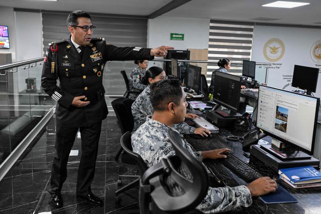 Colonel Rodolfo Blancas, Director of Planning and Supervision for Highways, Airports, Ports, and Borders of Mexico's National Guard, explains the operation of a road monitoring center during an interview with AFP at the National Guard headquarters in the Iztapalapa district of Mexico City on March 30, 2022. Cargo transport robbery in Mexico has decreased in recent months, which authorities attribute to measures they have implemented to prevent this crime, such as monitoring and escorting tractor?trailers. (Photo by Yuri CORTEZ / AFP)