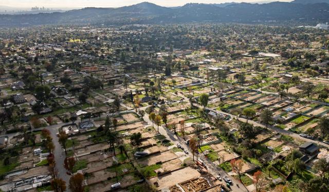 TOPSHOT - In this aerial view, thousands of empty lots and construction projects show the rebuilding of an area burned by the Eaton fire nearly one year ago in Altadena, California, on January 5, 2026. (Photo by JOSH EDELSON / AFP)